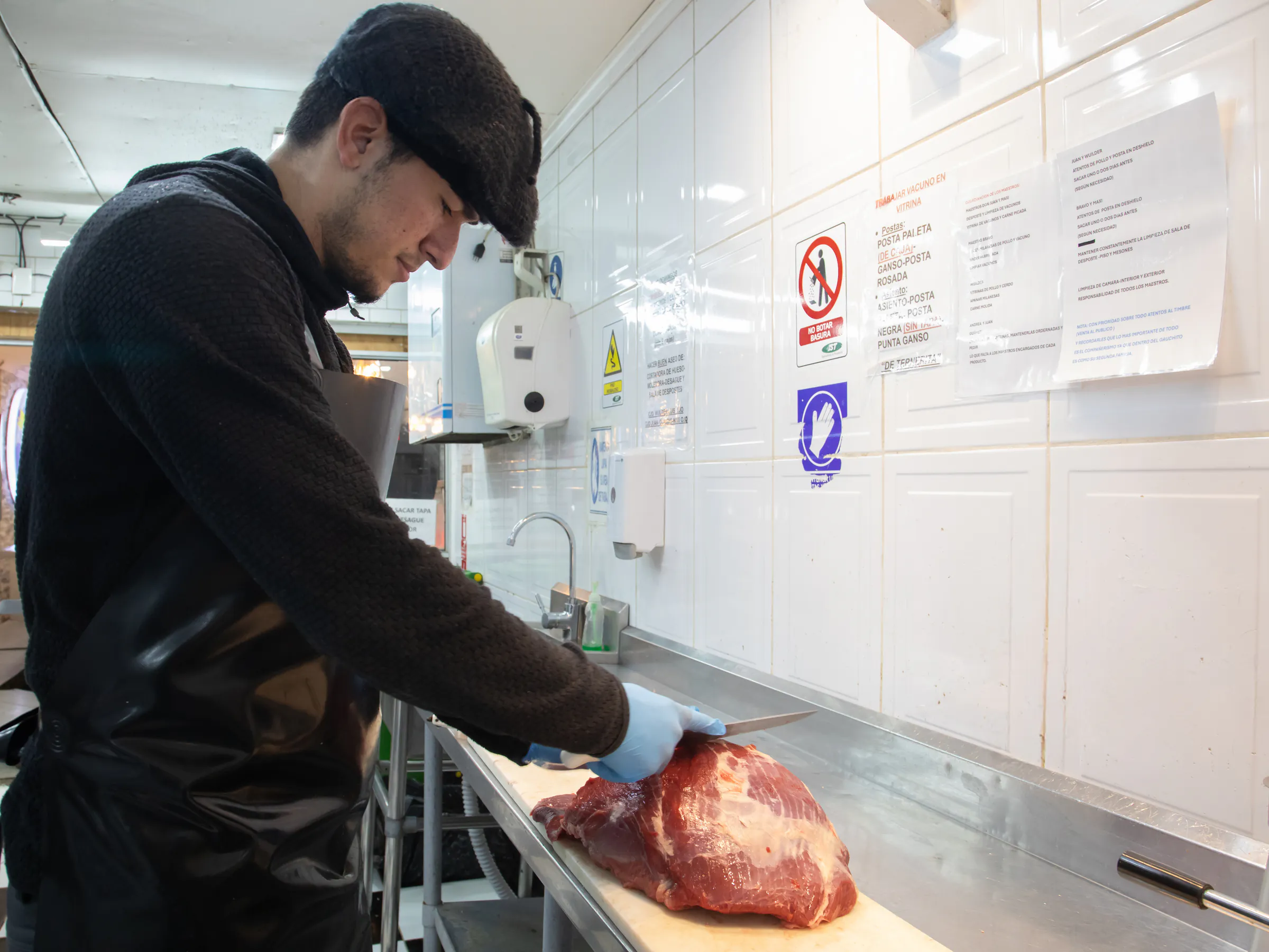 Carnicero de El Gauchito preparando un corte en la sala de trabajo