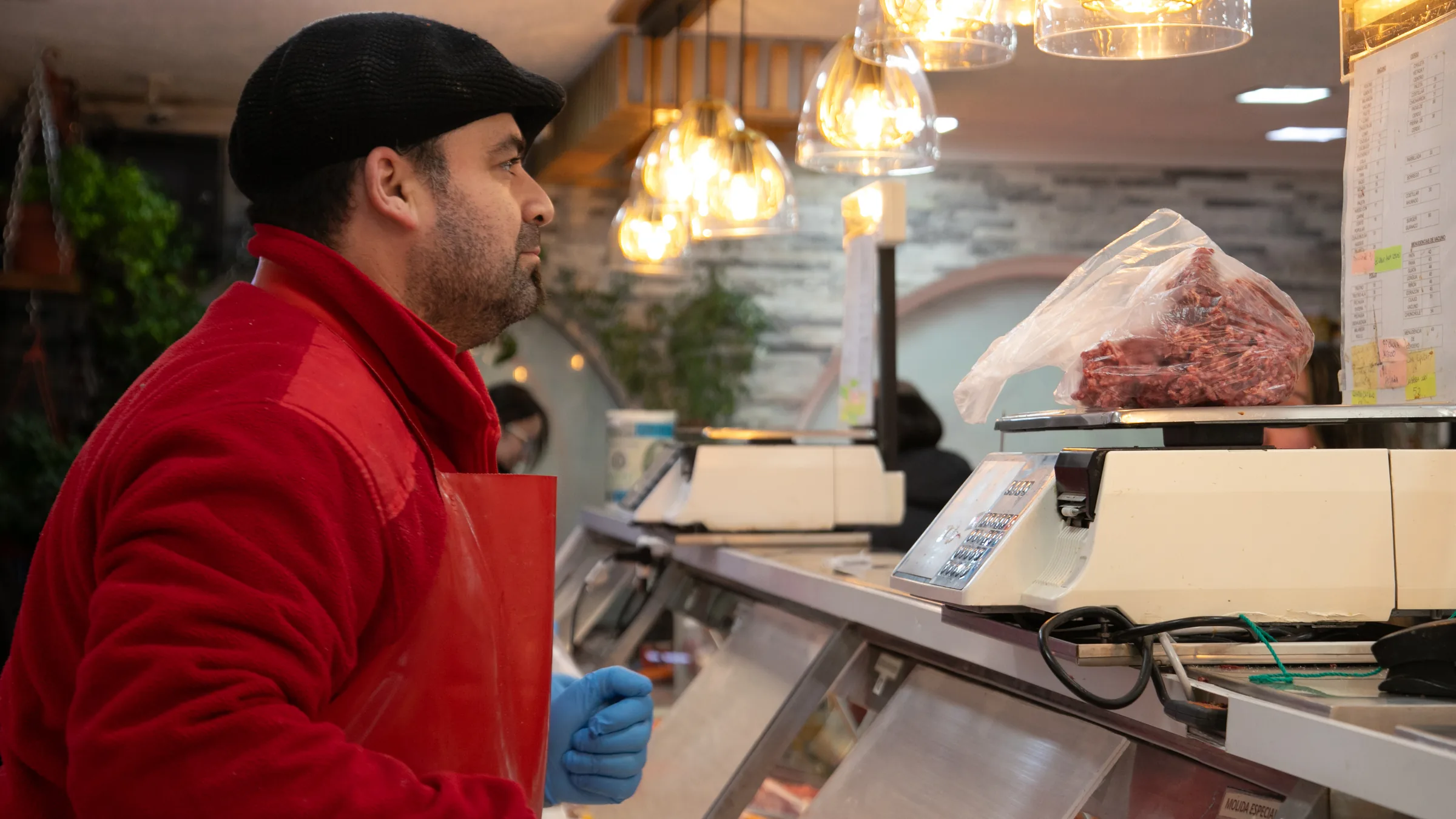 Carnicero de El Gauchito trabajando junto a una balanza y la vitrina